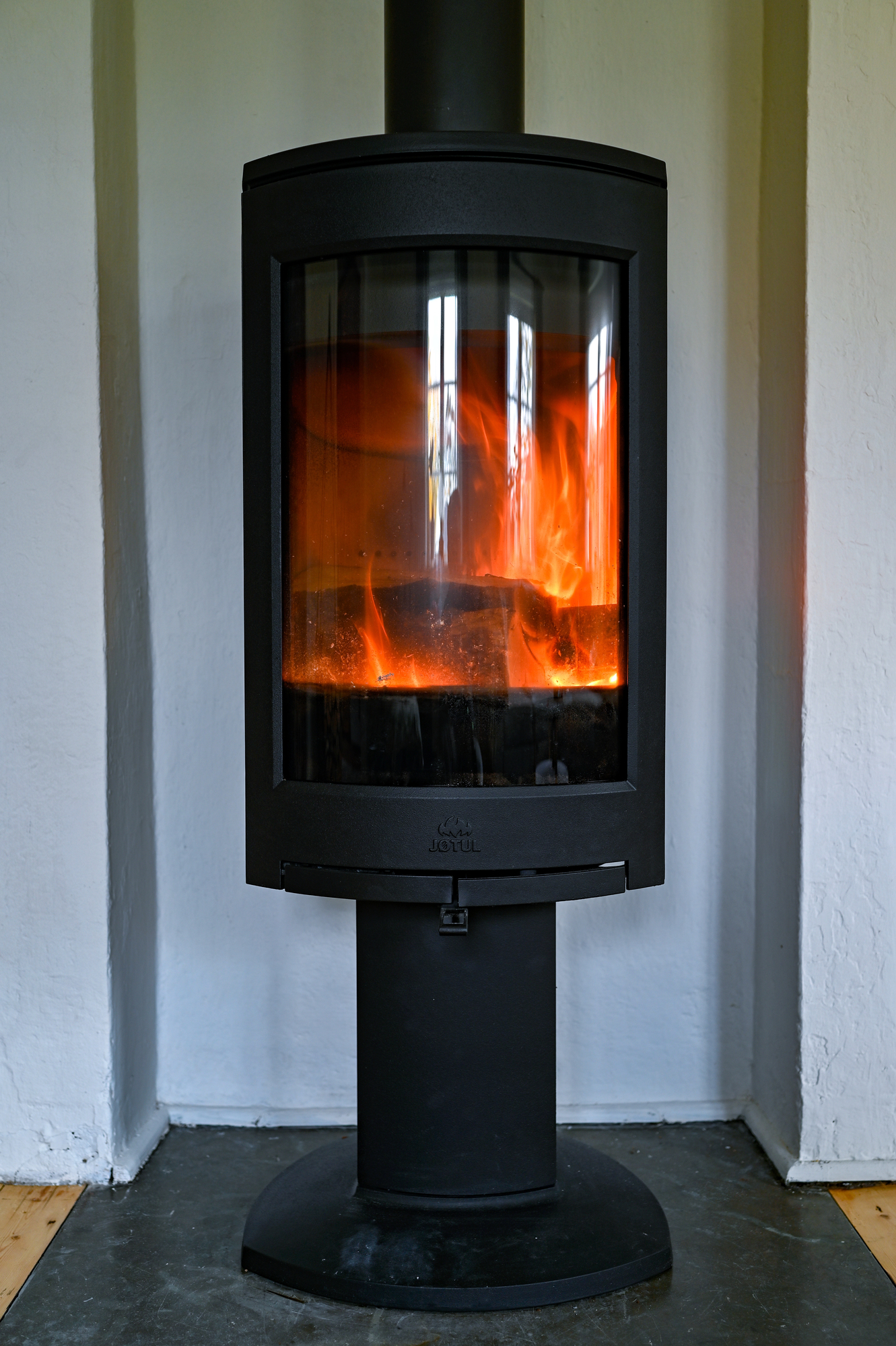 A classic wood burning stove with a glowing fire inside